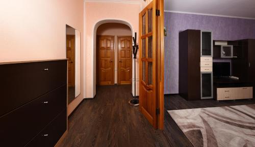 オムスクにあるпроспект Мира 66のウッドフロアの廊下、木製のドアが備わる客室です。