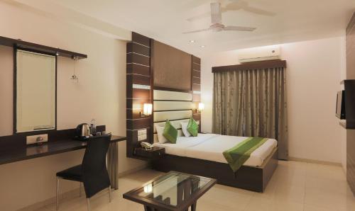 a hotel room with a bed and a desk and a table at Hotel Apple Inn Vapi in Vapi