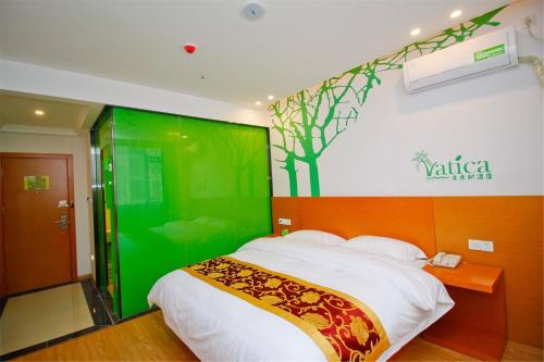- une chambre dotée d'un lit avec un mur vert dans l'établissement Vatica Xuzhou High Speed Railway Station Hotel, à Xuzhou