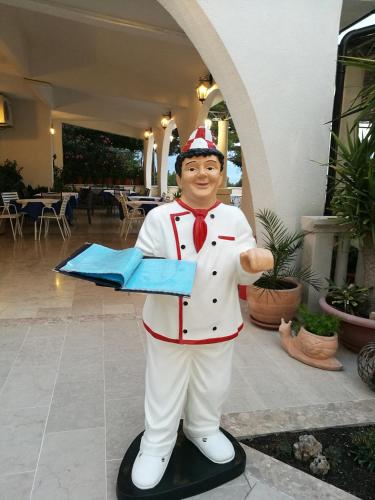 a statue of a chef holding a piece of paper at Skalinada Sea View in Lokva Rogoznica