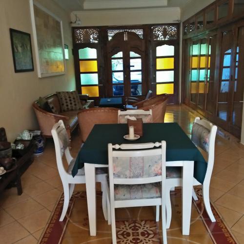 a dining room with a green table and chairs at Rumah Desa Homestay in Prambanan