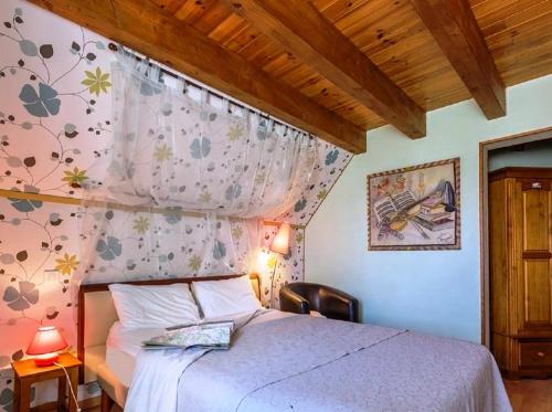 1 dormitorio con cama, cortina y silla en Domaine de la Chaux de Revel en Saint-Martin-Valmeroux