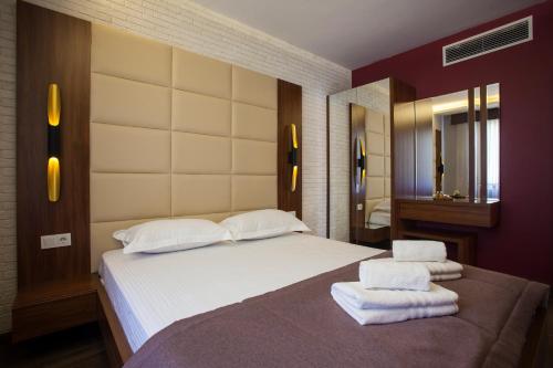 a bedroom with a large bed with towels on it at Maxuite Hotel in Home in Akçay