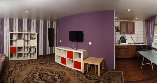 オムスクにあるмира 27の紫の壁のリビングルーム(テレビ付)