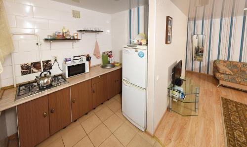 オムスクにあるмира 25のキッチン(白い冷蔵庫、電子レンジ付)