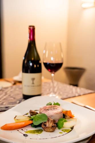a plate of food and a glass of wine at De Old Drift Guest Farm in Addo