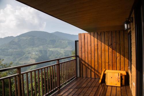 a bench sitting on a balcony with a view of mountains at The fairy land - Lala Mountain in Fuxing
