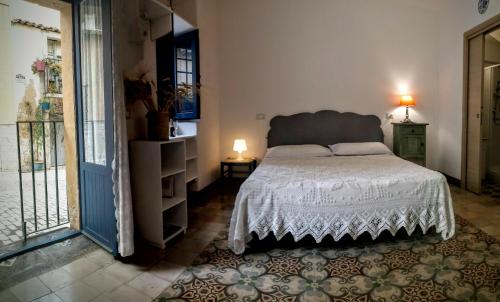 a bedroom with a bed with a white comforter at Dimore Sicule Noto in Noto