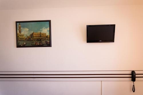 a flat screen tv on a wall with a painting at Hotel Zamca Suceava in Suceava