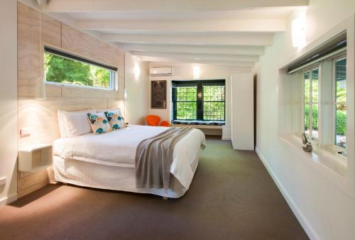 een slaapkamer met een bed en 2 ramen bij The Gallery Olinda in Olinda
