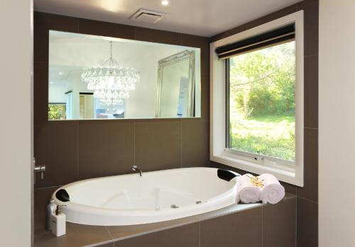 uma banheira na casa de banho com uma grande janela em The Gallery Olinda em Olinda