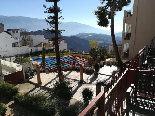 a view of a swimming pool with mountains in the background at Hotel Andalucia in Lanjarón