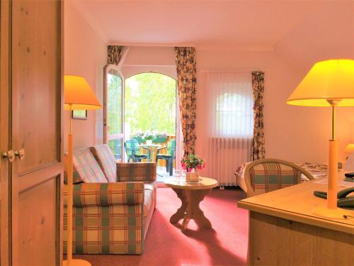 a living room with a couch and a table at Landhaus Müritzgarten Hotel garni in Röbel