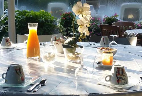 a table with a white table cloth and orange juice at Camping La Digue in Chauzon