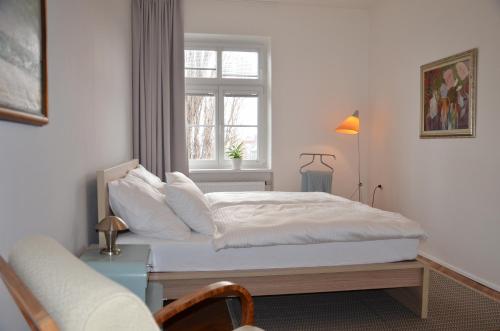a bedroom with a white bed with a window at Apartmán u Masaryka in Hodonín