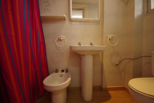 a white bathroom with a sink and a toilet at Apartamentos Los Pinos in Calpe