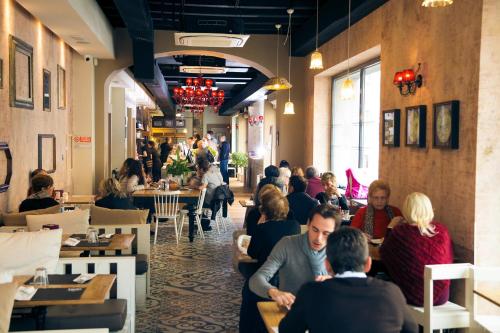 eine Gruppe von Personen, die in einem Restaurant an Tischen sitzen in der Unterkunft Amalia Bakery Home in Gallarate