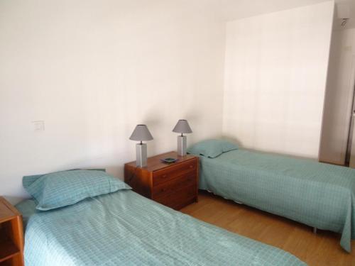 リスボンにあるBlack&White - Entrecamposのベッドルーム1室(ベッド2台、ランプ2つ付きドレッサー付)