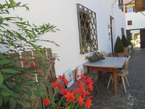 a table and chairs in a courtyard with flowers at Garni Reider in Meltina