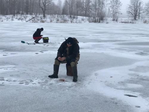 a man sitting on a bench in the snow at Dzirnavkalns in Cesvaine