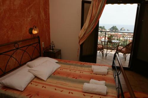 a bedroom with a bed with a view of a balcony at Katsios Studios in Parga