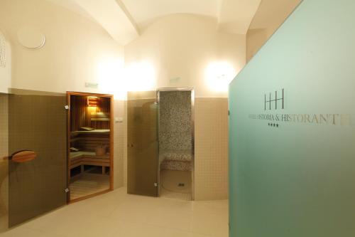 a bathroom with a walk in shower in a room at Hotel Historia & Historante in Veszprém