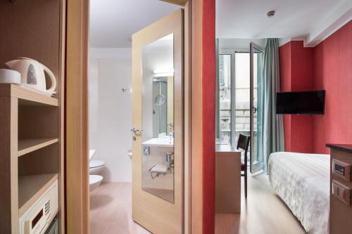a bedroom with a bathroom with a sink and a mirror at Best Western Porto Antico in Genoa