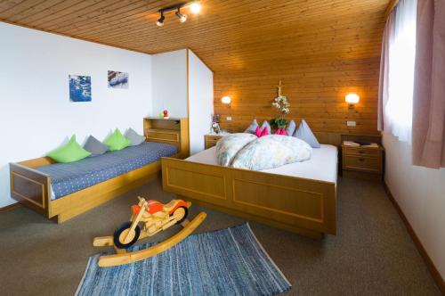 a bedroom with two beds and a childs toy at Garni Reider in Meltina