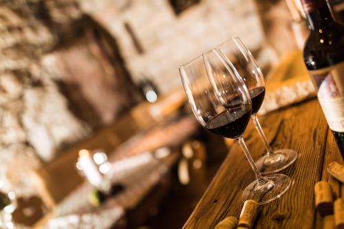 two glasses of wine sitting on a wooden table at Hotel Patriarch in Tirolo