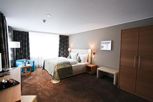 Cette chambre comprend un lit et une grande fenêtre. dans l'établissement Hotel Palatina "Hotel-Restaurant", à Neustadt an der Weinstraße