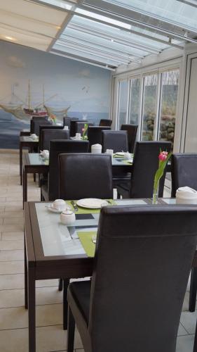 a dining room with tables and chairs and the ocean at Hotel Sylter Hof in Westerland (Sylt)