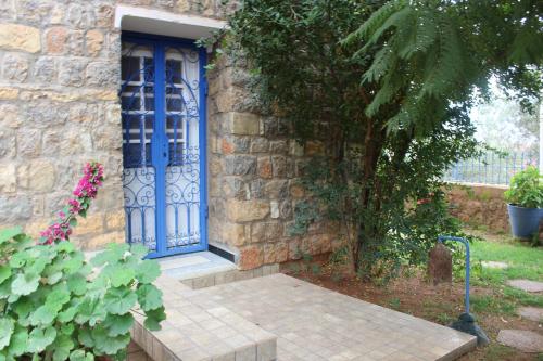a blue door on the side of a stone house at Tigmi Dar Samy in Bine el Ouidane