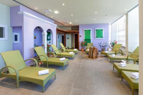 a waiting room with green chairs and tables at Garden Suites Umag Plava Laguna in Umag