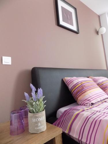a bedroom with a bed and a table with a flower pot at Colosseum Residence in Bucharest