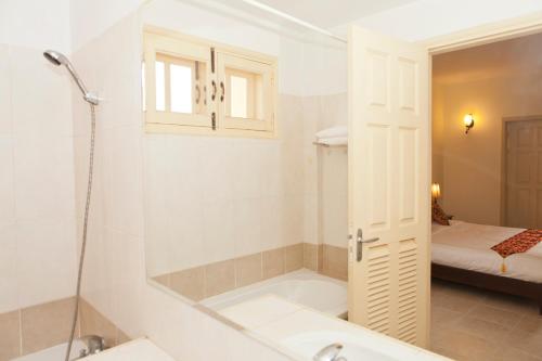 a white bathroom with a tub and a sink at Grand Residence in Phnom Penh