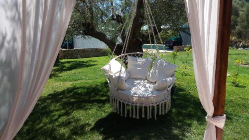 a swinging chair in a yard with curtains at Fillis House in Vourvourou