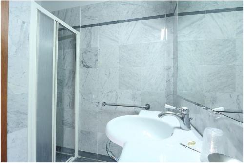 a white bathroom with a sink and a shower at Hotel Arcadia in Florence