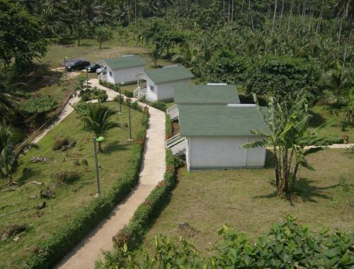 a group of houses in a field with a road at N`Guembú Nature Resort in Porto Alegre
