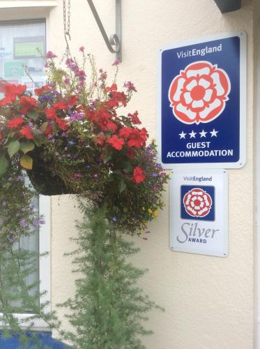 a sign on the side of a building with flowers at Blue Waters Lodge in Paignton