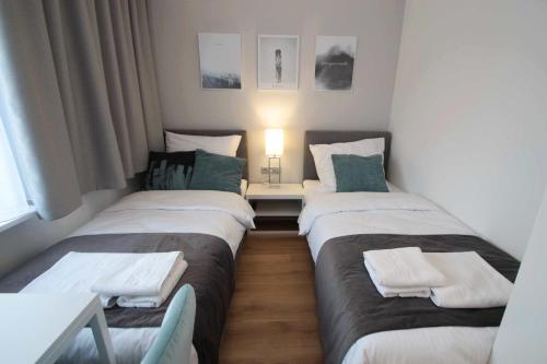 two twin beds in a small room with a table at Hotel Coliber in Kłobuck