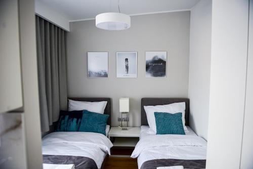 two beds sitting next to each other in a bedroom at Hotel Coliber in Kłobuck