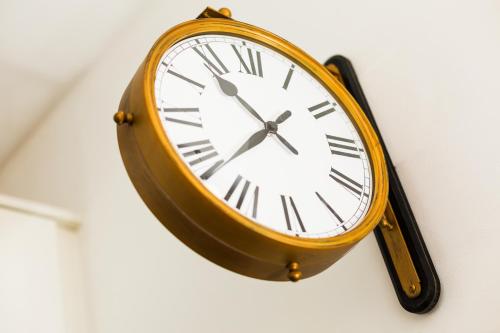 a clock is hanging on a wall at Apartamentos Cornellalux in Cornellà de Llobregat