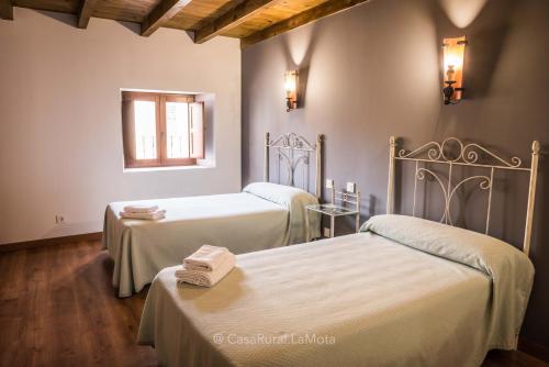 AstudilloにあるCasa Rural "La Mota"のベッド2台と窓が備わる客室です。