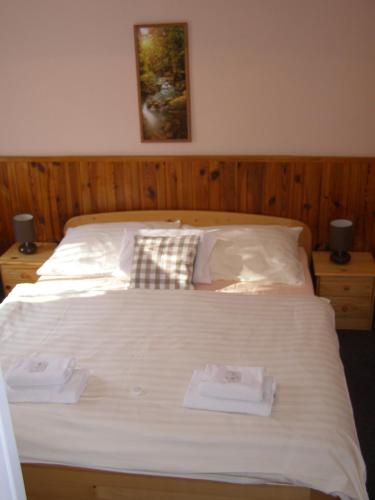 a bedroom with a bed with two towels on it at Hotel Garni Belveder in Hřensko