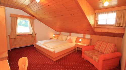 een kleine slaapkamer met een bed en een stoel bij Bed and Breakfast Iman in Santa Cristina in Val Gardena