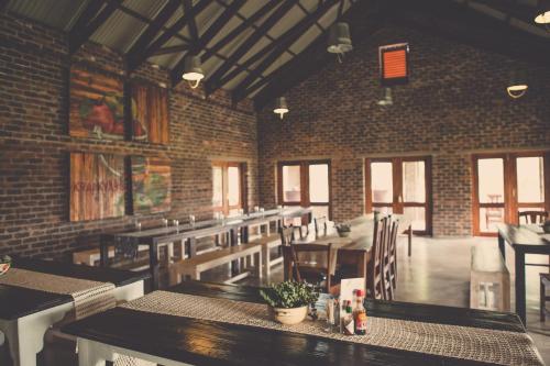 un restaurante con mesas y sillas y una pared de ladrillo en Grincourt B&B- with No Load shedding en Polokwane