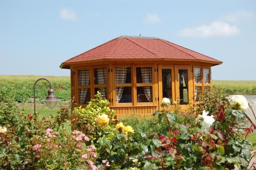a small wooden gazebo in a garden with flowers at Heu-Ferienhof Altkamp in Putbus