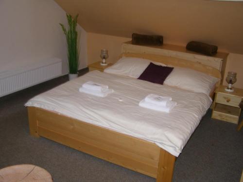 a bedroom with a bed with two towels on it at Hotel Garni Belveder in Hřensko