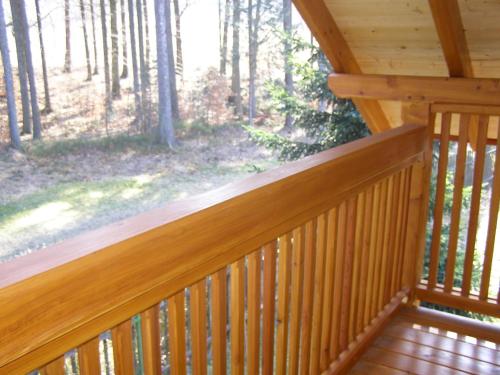 a wooden deck with a view of the woods at Hotel Garni Belveder in Hřensko