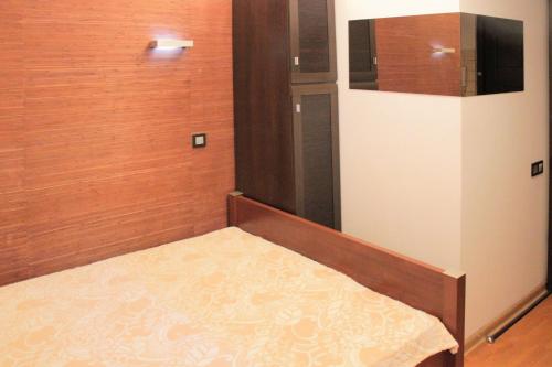 a small bed in a room with wooden walls at Apartments On Centralny Rynok in Kaliningrad